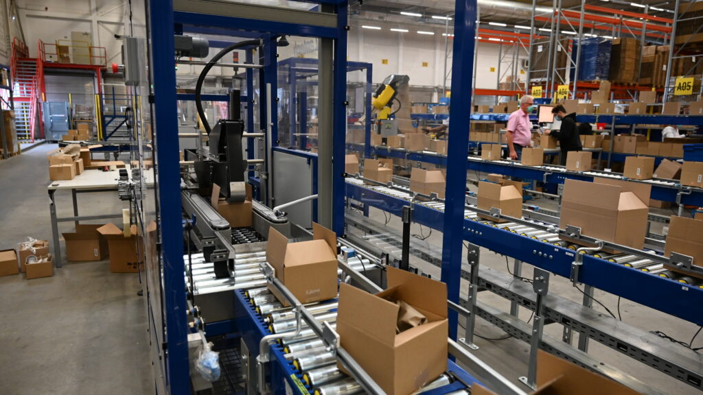 boxes going into case sealer to be closed and sealed